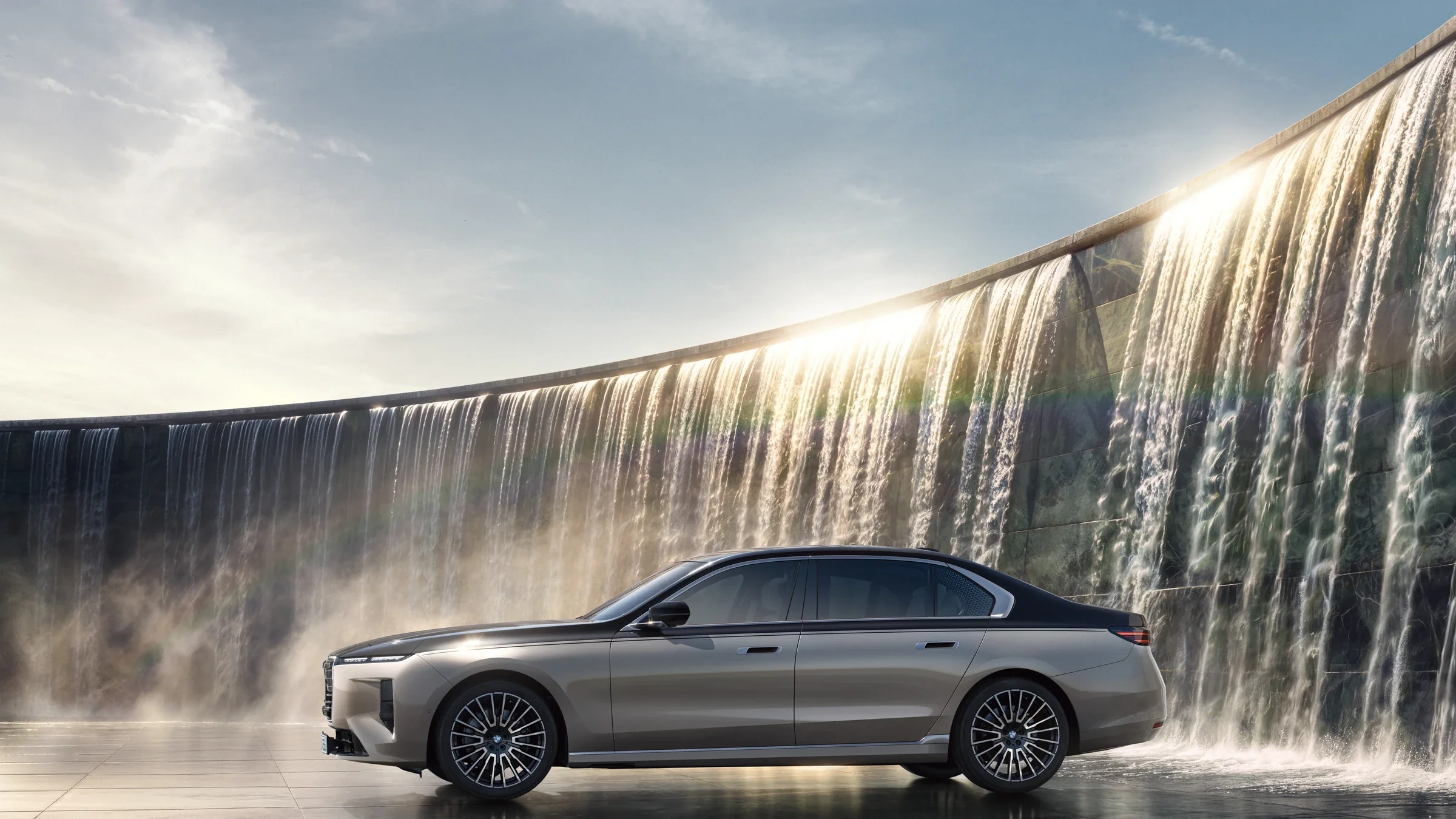 BMW 7er in Seitenansicht vor moderner Wasserarchitektur