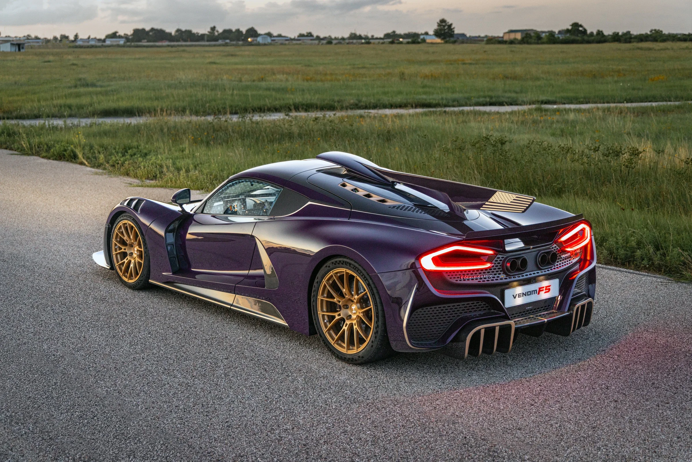 Hennessey Venom F5-M Roadster von hinten mit goldenen Rädern und sichtbarer Carbonkarosserie