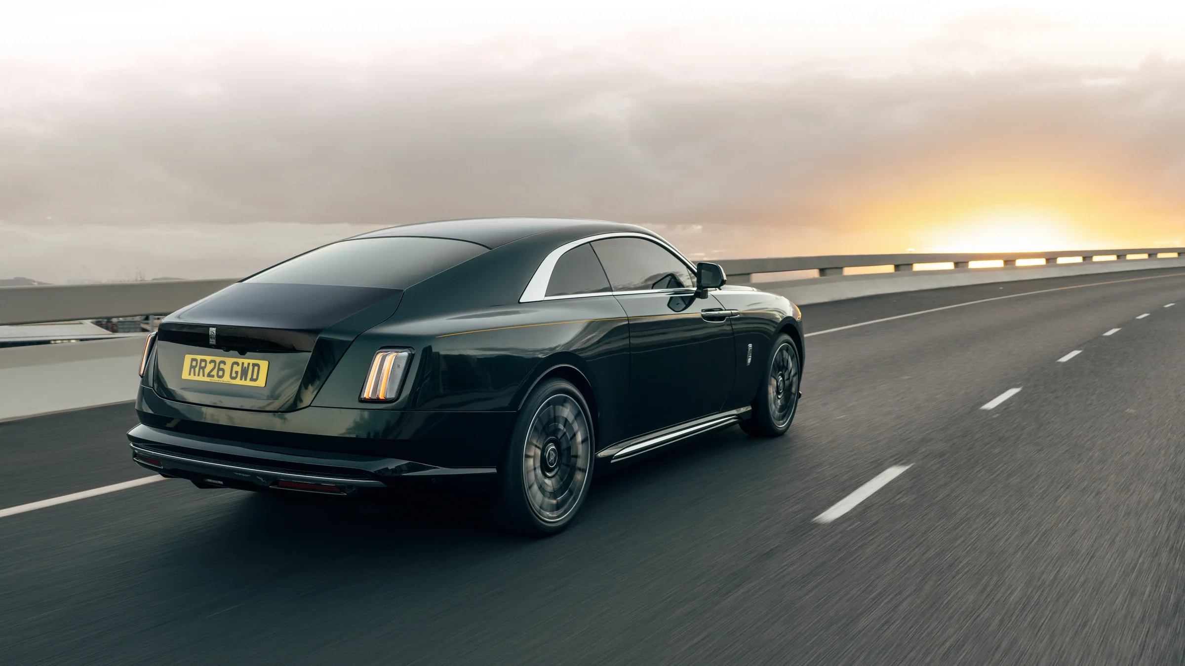 Rolls-Royce Spectre Series II bei Sonnenuntergang auf einer Küstenstraße