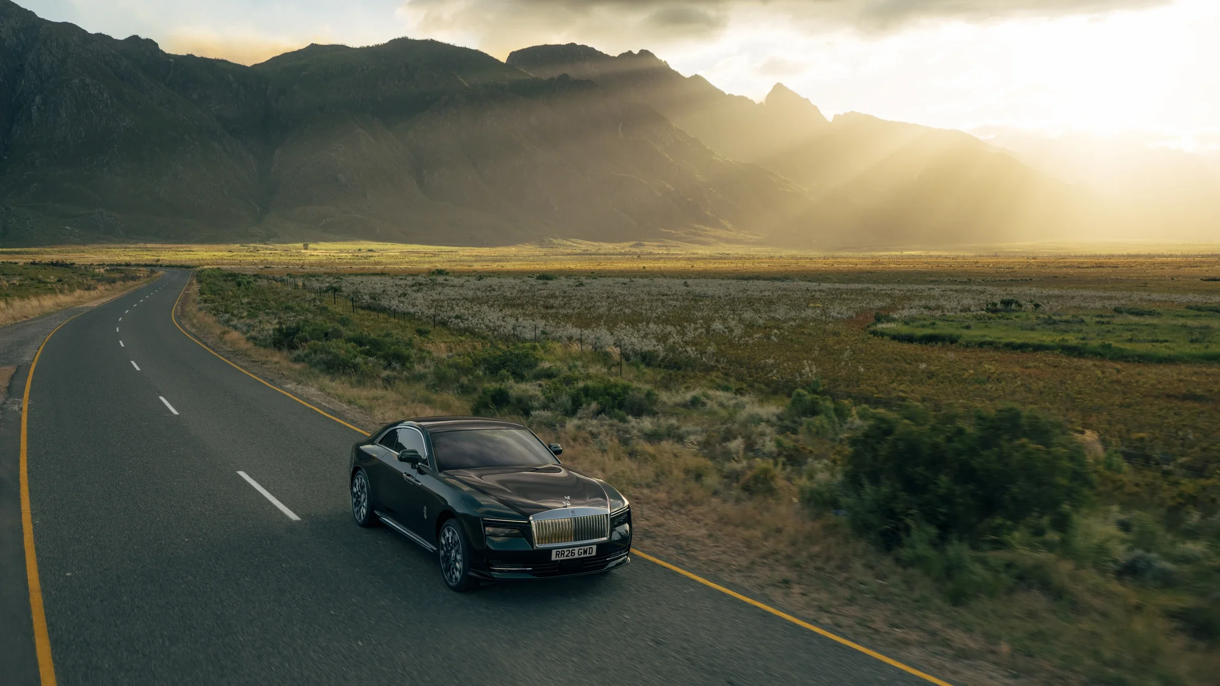 Rolls-Royce Spectre Series II auf ruhiger Landstraße bei Sonnenuntergang