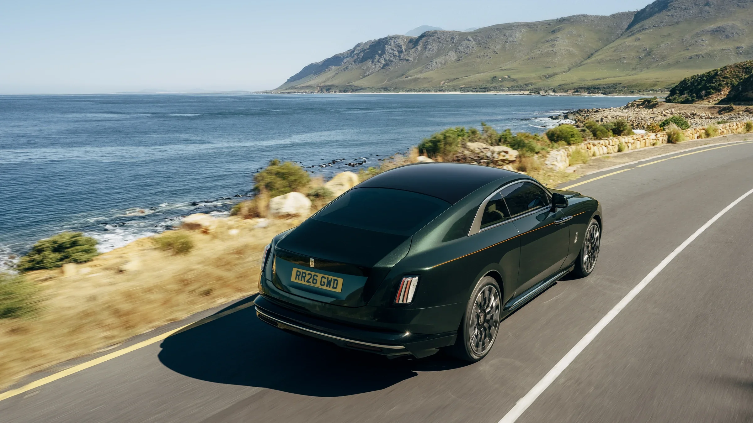 Rolls-Royce Spectre Series II auf einer Küstenstraße mit Meerblick